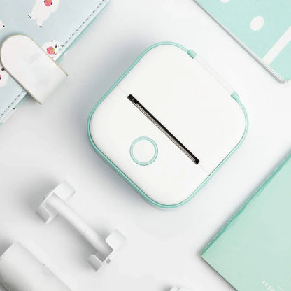 Beckett portable printer with compact design, white color, and connected cables, ready for on-the-go printing.