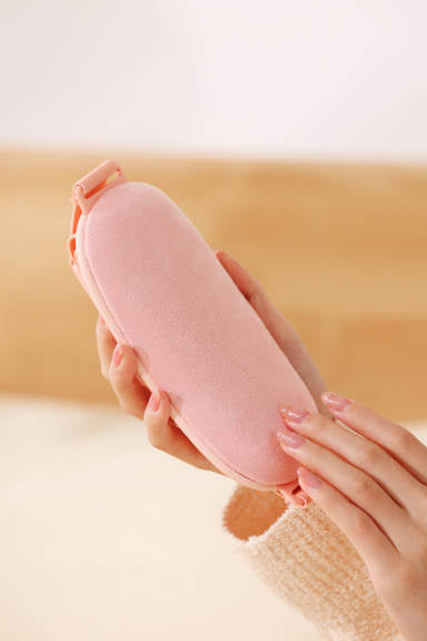 Beckett Menstrual Massager with ergonomic design shown from the back, featuring soft pad for abdominal pain relief.