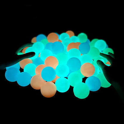 Beckett Sticky Glow Balls glowing in the dark, flexible and textured for fun indoor and outdoor play, shown against a dark background.